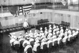 Chef Mathieu speaks to the Davenport's culinary team in 1922