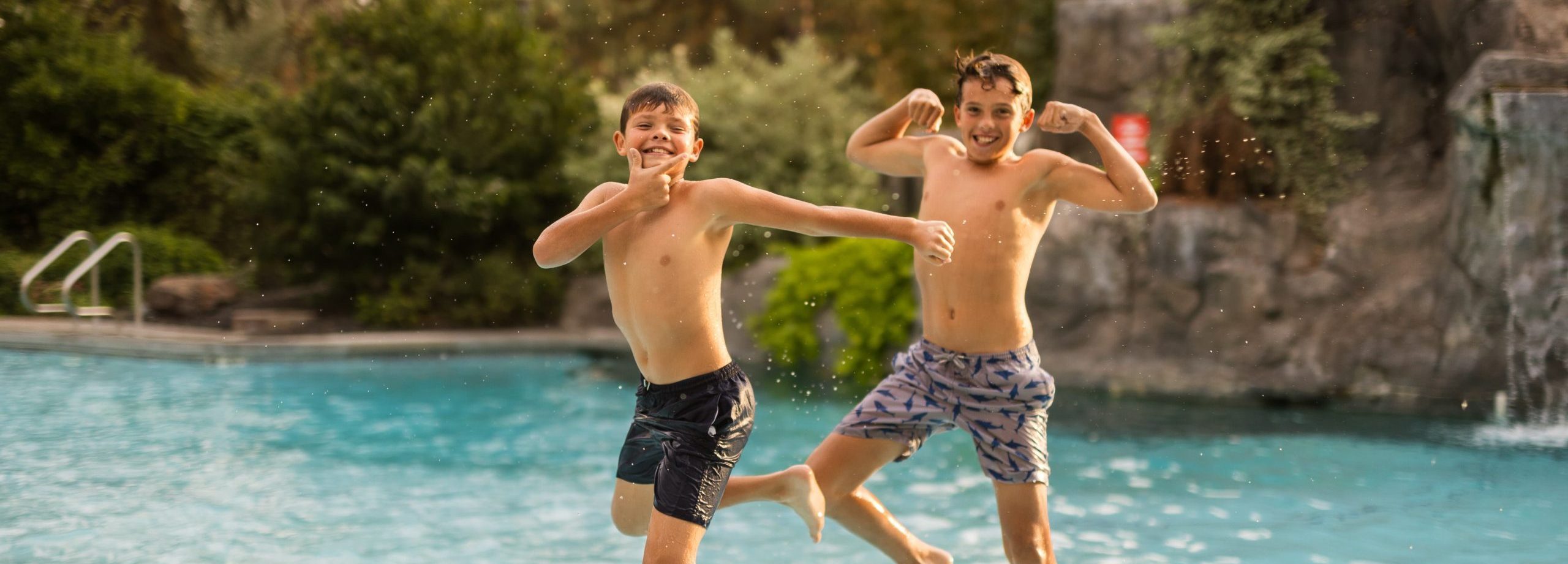 two boys jumping in pool